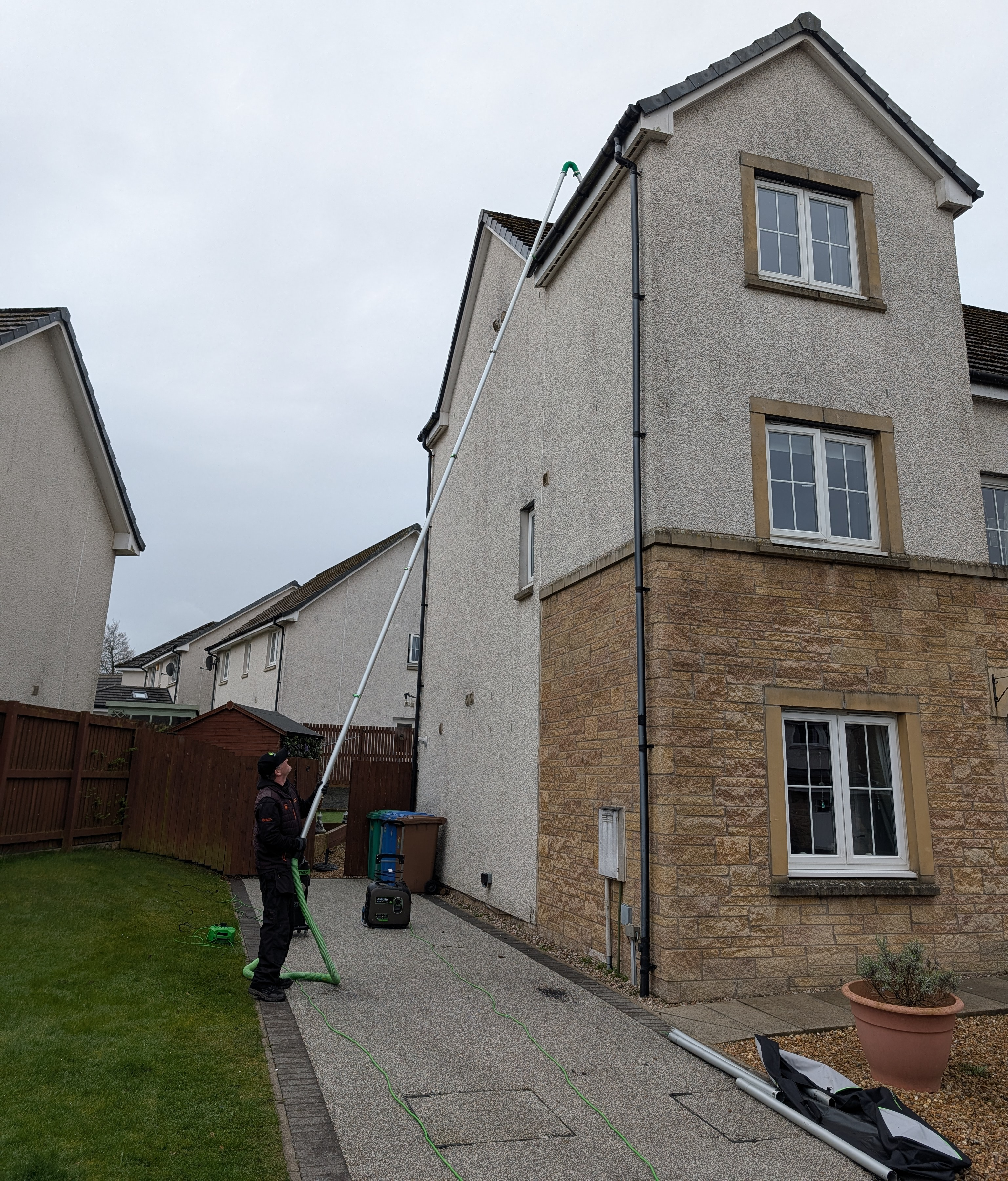 Gutter cleaning using vacuum system on a three-storey house in Fife